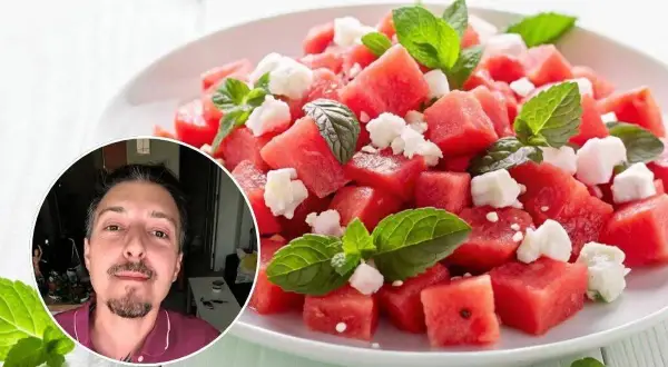 Un hombre sonriente se asoma junto a una refrescante ensalada de sandía con queso feta y menta. ¡Perfecta para el verano!