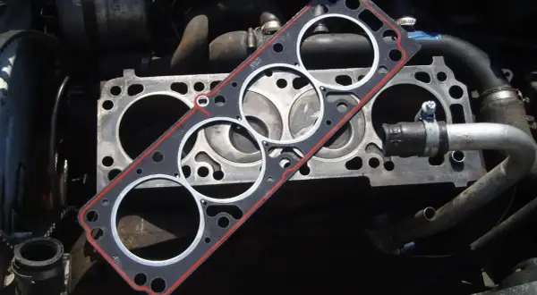Nueva junta de culata lista para cambiar la vieja. El motor está desarmado, esperando la reparación.