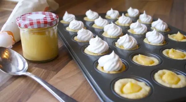 Kleine Törtchen mit Baiserhauben und einer Füllung aus Lemon Curd, bereit für köstliche Rezepte mit Lemon Curd.