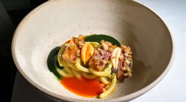 Un piatto di pasta con frutti di mare, salsa verde e rossa, croccantezza e un tocco da ciccio sultano stelle michelin.