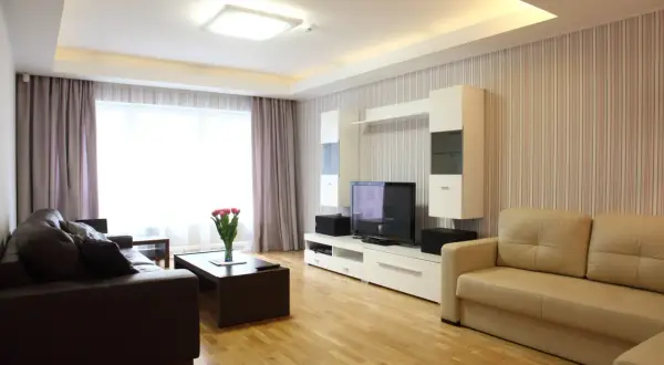 Nowoczesny salon z dwupoziomowym sufitem podwieszanym i wbudowanymi lampami.
