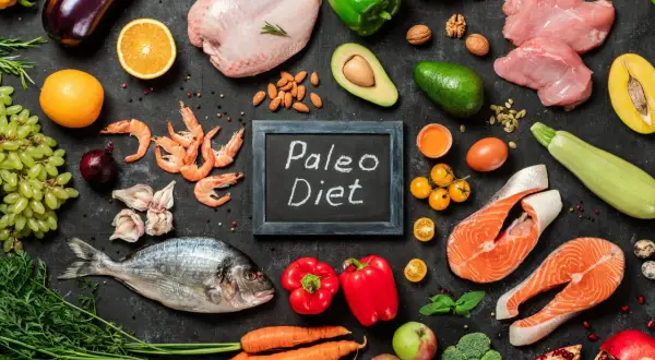 Ingredienti freschi per la dieta paleo: pesce, carne, verdura, frutta, uova e noci.