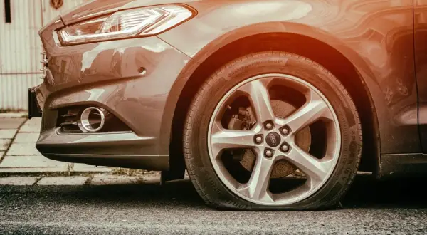 Pneu à plat sur une Ford. L'inconvénient d'une bombe anti-crevaison est qu'elle ne peut pas réparer une crevaison aussi grave.