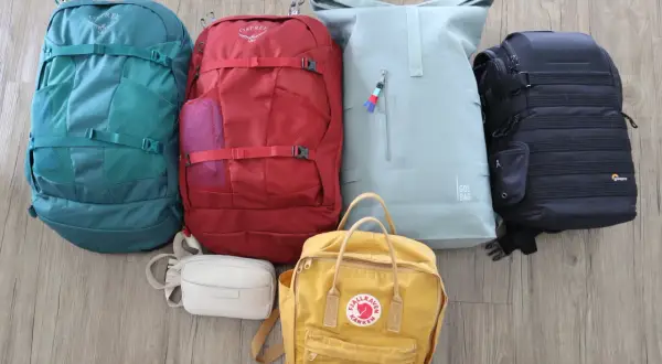Sechs Rucksäcke in verschiedenen Farben und Größen, bereit für eine Weltreise und Backpacking.