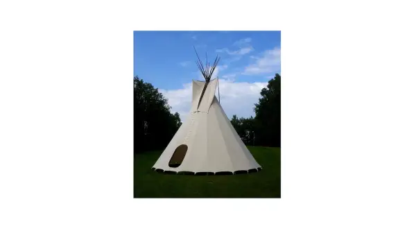 Gotowe tipi ze stabilizatorem, gotowe do rozłożenia na trawie, pod błękitnym niebem.