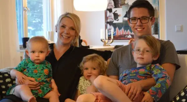 Famille souriante, avec deux enfants sur les genoux des parents. Le nom de famille suédois est Johansson.