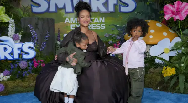 Rihanna z dziećmi na tle Smerfów. Mama tuli jedno dziecko, drugie stoi obok.
