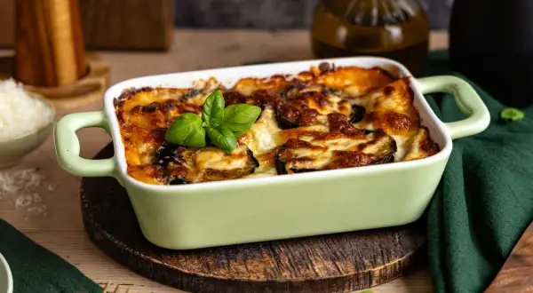Herzhafte Auberginen Lasagne, goldbraun überbacken mit Käse und garniert mit frischem Basilikum. Ein Genuss für alle Sinne.