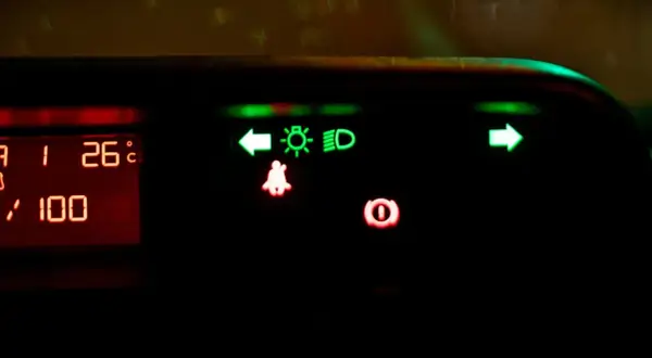 Na desce rozdzielczej świecą się zielone kontrolki: kierunkowskaz lewy, światła mijania, światła drogowe (high beam assist) i kierunkowskaz prawy. Czerwone kontrolki: pasy i hamulec.