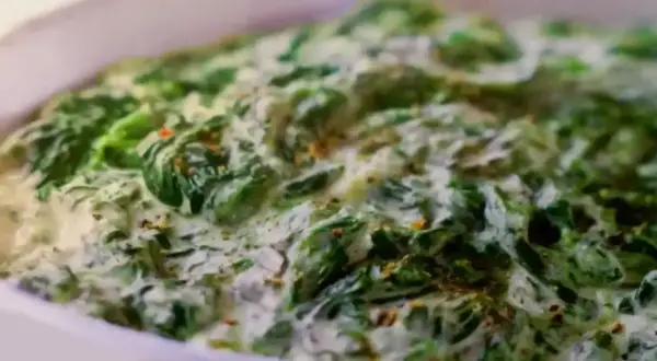 Un plat réconfortant d'épinards à la crème, parsemé d'épices, prêt à être dégusté.