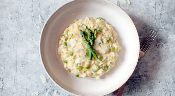 Cremiges Spargel-Erbsen-Risotto, garniert mit frischem Spargel und Parmesan. Ein köstliches Beispiel, was ist risotto.