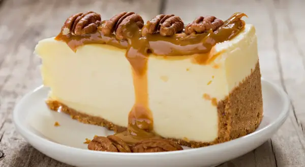 Deliciosa tarta de queso con dulce de leche y nueces pecanas, un postre irresistible.