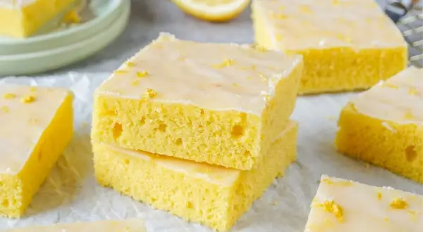 Saftiger zitronenkuchen blech, mit Zuckerguss und Zitronenschale bestreut, bereit zum Genießen.