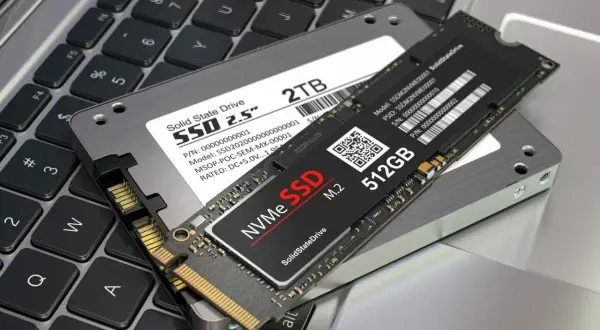 Dwa dyski SSD: 2.5-calowy 2TB i smukły M.2 512GB, leżą na klawiaturze laptopa. To nowoczesne rozwiązania, które pokazują, co to SSD.