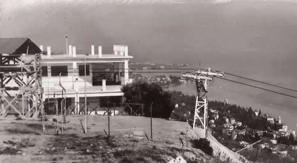 Stazione della funivia con vista panoramica su San Michele Salò e il lago. Montagne innevate sullo sfondo.