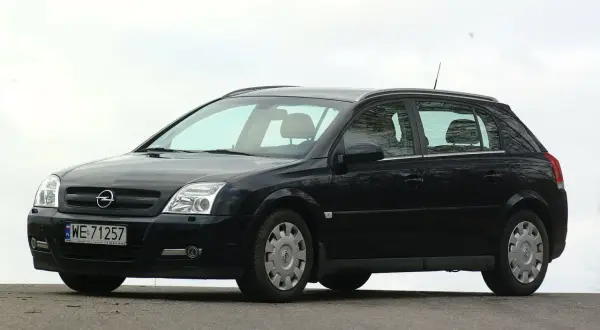 Czarny Opel Signum z czystymi żarówkami reflektorów, zaparkowany na zewnątrz.