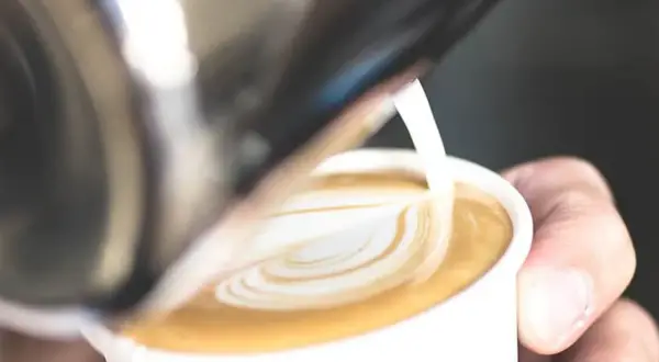 Latte art: il latte montato crea un cuore sulla schiuma del caffè.