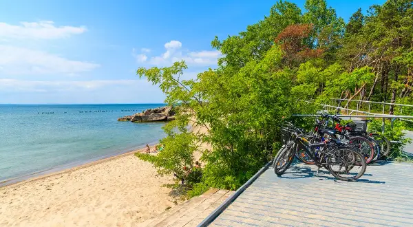 Rowerami po wybrzeżu – odkryj najpiękniejsze trasy rowerowe w Polsce! Piękna plaża, spokojne morze i zielony las zapraszają na aktywny wypoczynek.
