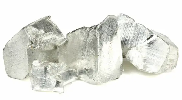 Pezzi grezzi di metallo argenteo, con striature evidenti, che ricordano un rivestimento in stagno grezzo.