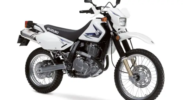 Biały motocykl Suzuki DR650SE, idealny na lekkie enduro turystyczne, gotowy na przygodę.