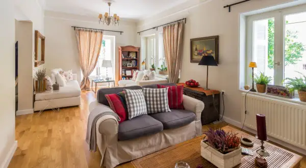 Przytulny salon z sofą, książkami i kwiatami, idealny na angielskie przyjęcie.