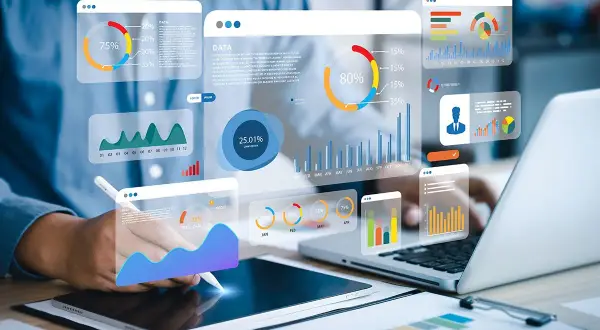 Big data scientist analizujący wykresy i dane na ekranach.