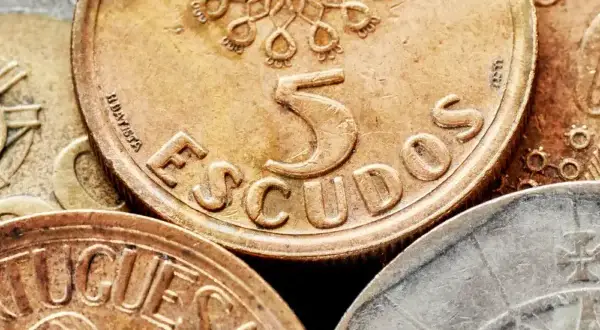 Złote monety z napisem "ESCUDOS" i cyfrą 5, dawna waluta Portugalii przed euro.