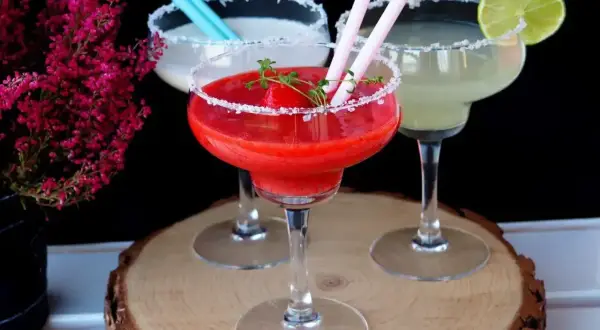 Trzy drinki margarita: jedna truskawkowa, jedna biała i jedna zielona.