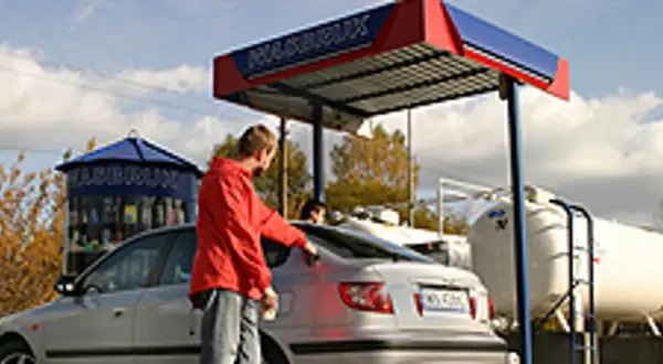 Mężczyzna tankuje samochód na stacji LPG. Ekologiczne rozwiązania lpg to przyszłość motoryzacji.