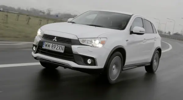 Biały Mitsubishi ASX 1.6 benzyna na mokrej drodze, z widocznym numerem rejestracyjnym WW 892XN.