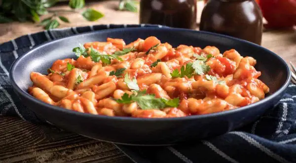 Piatto di pasta fagioli e cozze, un classico della cucina italiana, guarnito con prezzemolo fresco.