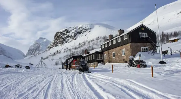 Vinterlandskap vid Nikkaluokta Kebnekaise med snöskotrar och fjällstation.