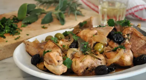 Piatto di coniglio alla cacciatora in bianco, con olive, cipolle e rosmarino. Un classico della cucina italiana.
