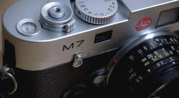Close-up of a Leica M7 camera, ready for a detailed review. The silver body gleams, showing the "M7" inscription and lens details.