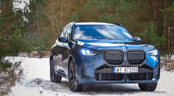 Nowy BMW X3 2024 w zimowej scenerii lasu, gotowy na każdą drogę.