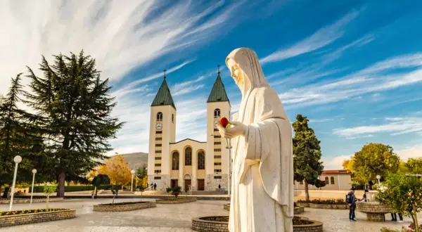 Pomnik Matki Bożej z różą przed kościołem. To miejsce objawień, nie tylko święte miasto.