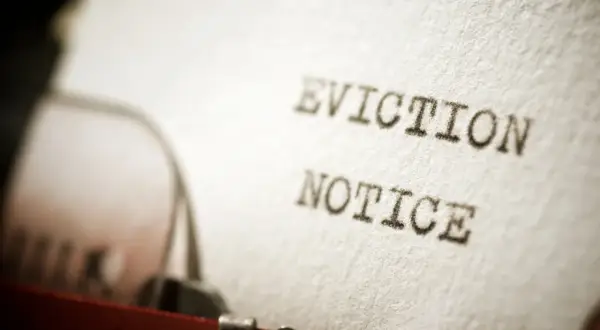 Foglio battuto a macchina con "EVICTION NOTICE", un precetto rilascio immobile cartabia che annuncia la necessità di lasciare un'abitazione.