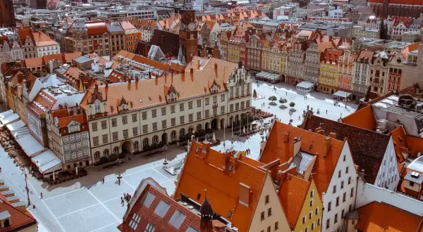 Widok z góry na Rynek we Wrocławiu z kolorowymi kamienicami i ratuszem.