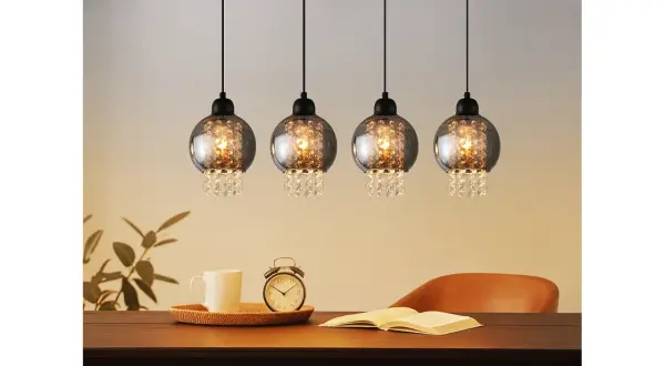 Elegancka lampa wisząca kryształowa z czterema kulistymi kloszami, ozdobiona błyszczącymi kryształkami, tworzy magiczny blask nad stołem.