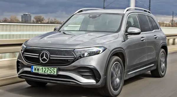 Szary Mercedes EQB jedzie po moście.