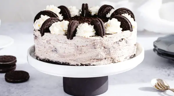 Wyjątkowe ciasto Oreo, udekorowane bitą śmietaną i ciasteczkami, kusi swoim wyglądem.