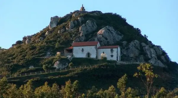 Edificio blanco con tejado rojo en la ladera rocosa del Pico Sacro.