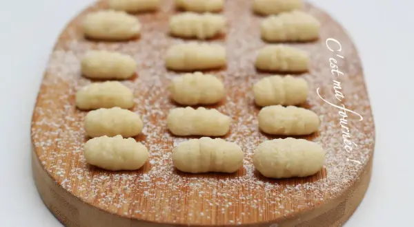 Gnocchis faits maison, une délicieuse pâte italienne à base de pomme de terre, saupoudrés de sucre glace sur une planche en bois.