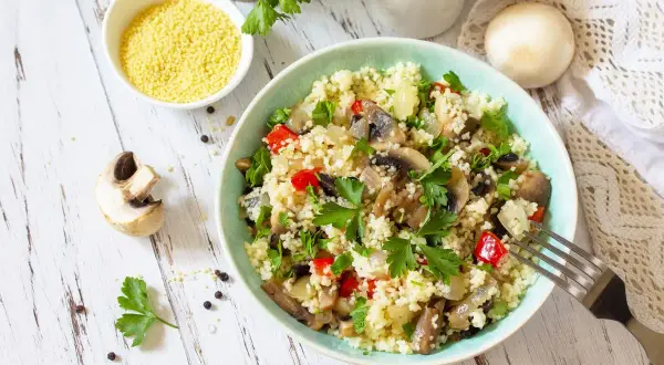 Un gustoso cous cous con funghi, peperoni e prezzemolo fresco. Un piatto leggero e saporito.