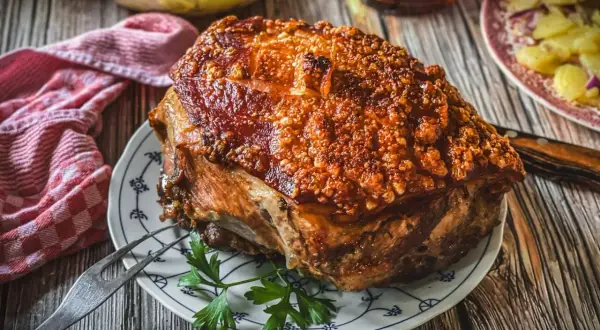 Knuspriger Schweinebraten mit goldbrauner Kruste, perfekt für ein deftiges Schweinebraten Rezept. Dazu gibt es Kartoffelsalat.