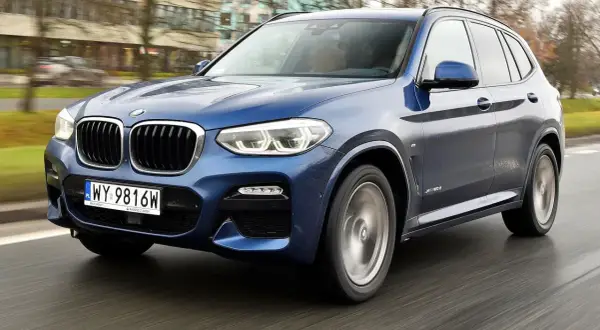 Niebieskie BMW X3 G01 w ruchu. Zastanawiasz się, bmw x3 g01 jaki silnik wybrać? Ten model oferuje wiele opcji.