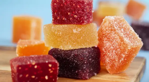 Délicieuses pâtes de fruits fait maison, colorées et enrobées de sucre, prêtes à être dégustées.