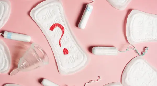 Podpaski, tampony i kubeczek menstruacyjny. Czerwony znak zapytania na podpaskach sugeruje niepewność, czy okres przyspieszony o tydzień to norma.