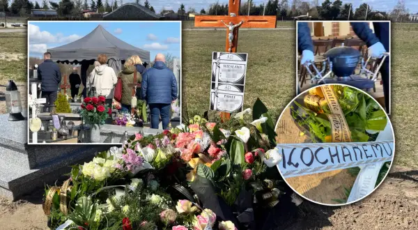 Cmentarz z namiotem pogrzebowym, krzyżem, wieńcami i zniczami.