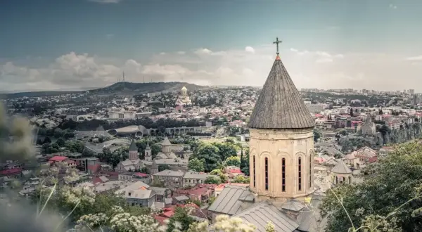 Widok na Tbilisi z kościołem w pierwszym planie. Marzysz o podróży? Sprawdź, ile trwa lot do Gruzji!